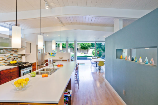 midcentury kitchen with blue accent wall and yellow lighting for a cozy feel