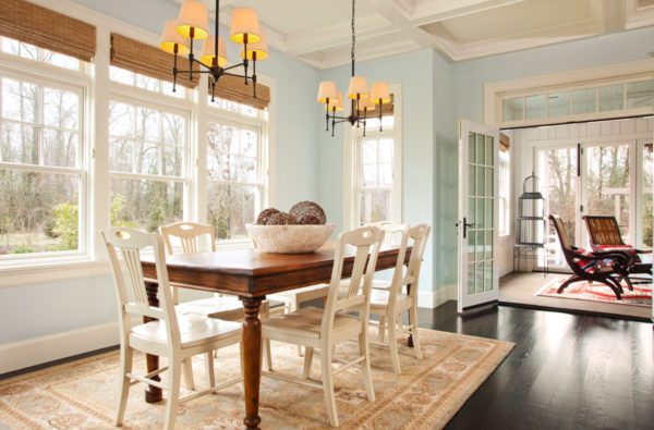 timeless wooden kitchen and dining room combo with pastel turquoise walls and warm lights