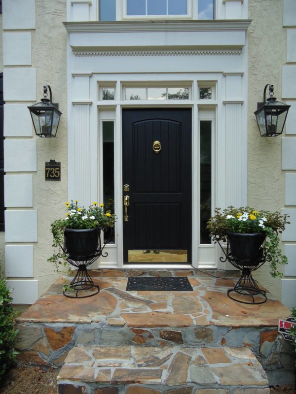 try a black front door color for a bold and timeless tan exterior