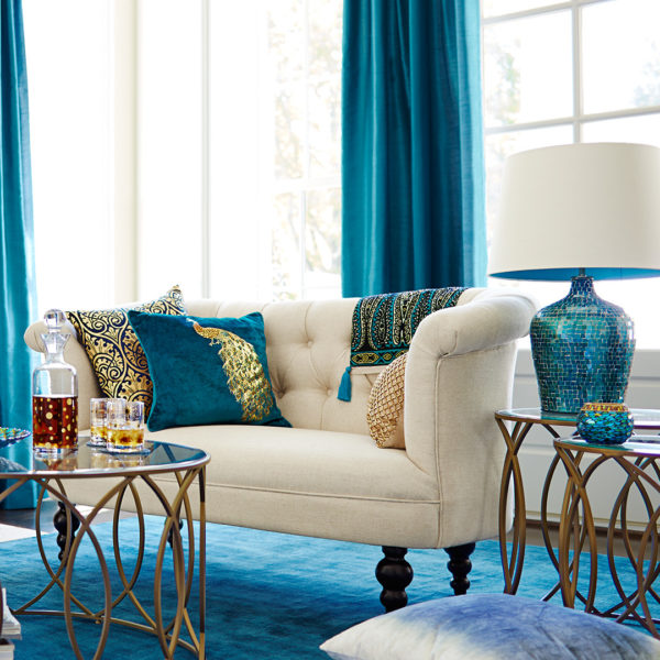 combine peacock blue curtains and rug with gold accents for an expensive-looking living room