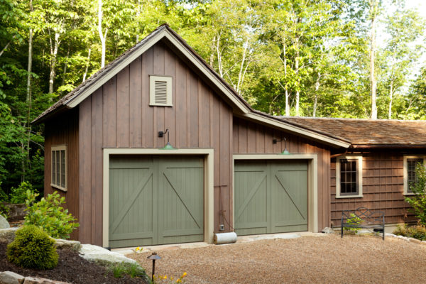 exquisite barn-inspired garage doors in sherwin williams garden gate (sw6167) with spanish moss siding for a rustic style