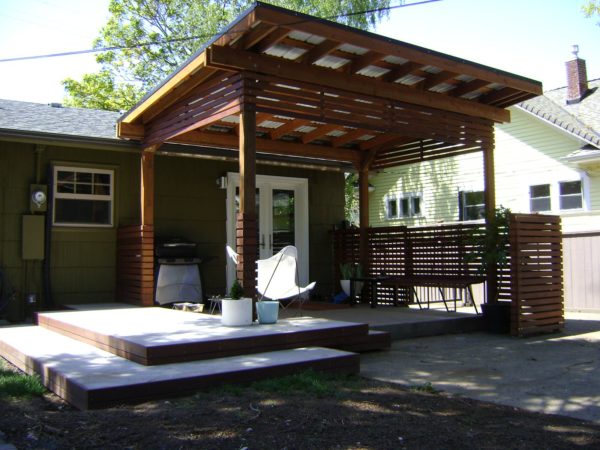 traditional metal roof pergola offers shade for a comfortable concrete patio