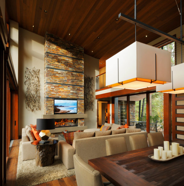 combine stone-clad linear fireplace with stunning tv in a dramatic mountain-style living and dining room
