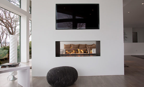 consider a black and white living room with a two-sided linear fireplace, mounted tv, and clean design