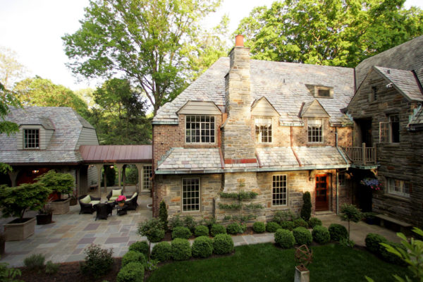 go back in time with a stunning stone build featuring a detached garage and breezeway with fairy lights