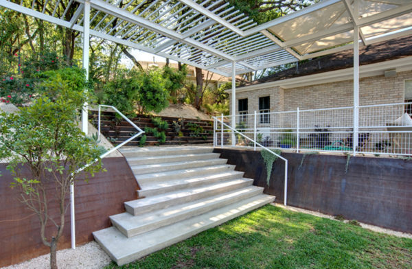 go for a modern landscape with white railings, metal pergola, and corten steel retaining walls