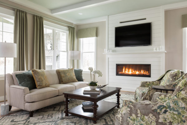 mix medium tone wood and white walls to enhance your linear fireplace with tv above in a comfy suburban home