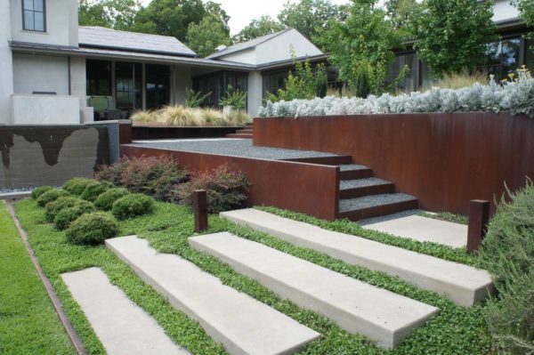 modern hillside home with contemporary landscaping and corten steel retaining walls