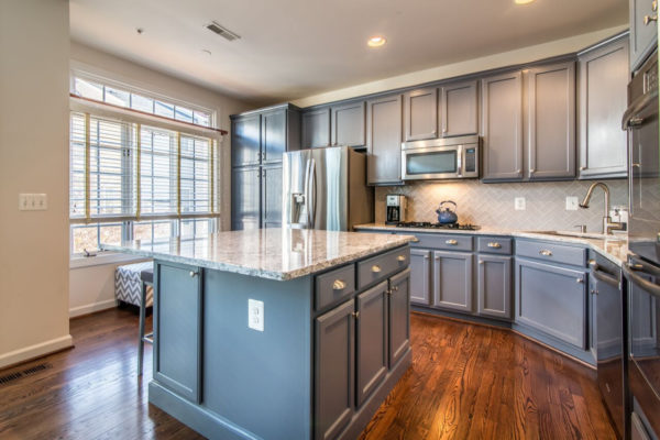 this transitional kitchen is the epitome of stylish remodel with grey cabinets and wood flooring
