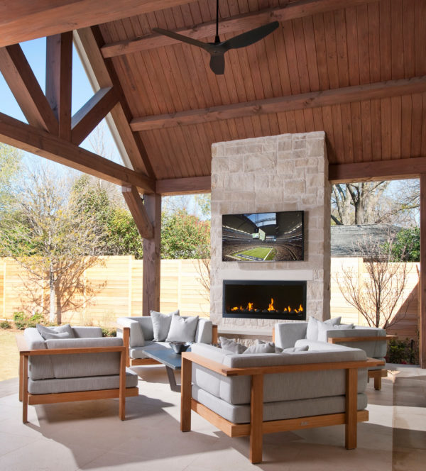 try a stone wall to hold linear fireplace with tv above in a charming semi-outdoor patio