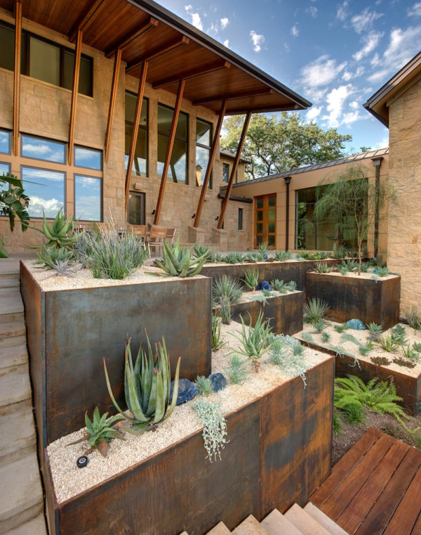 use corten steel retaining wall and concrete paver landscaping for a southwestern-inspired home