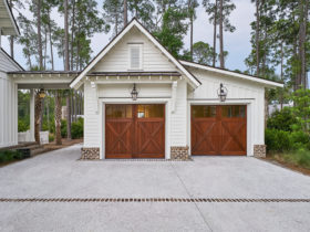 use traditional barn doors to complete a large country-styled detached garage with breezeway