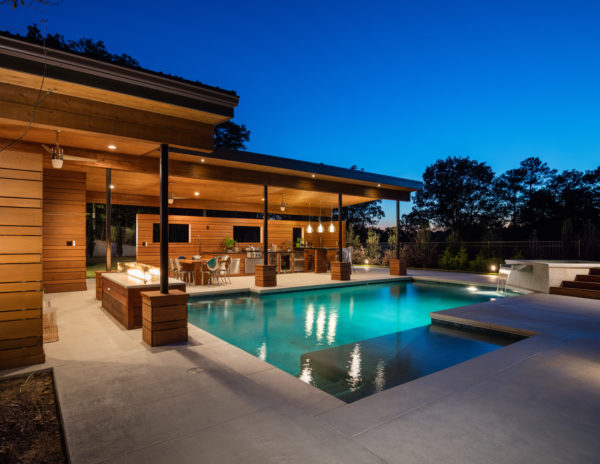 open air cabana and stamped concrete deck make for a luxury pool backyard
