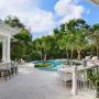pair stamped concrete pool deck with palm trees and outdoor bar for a beachside resort style backyard