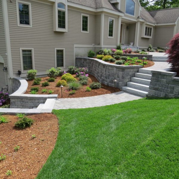 summer-ready front yard with natural stone retaining wall, concrete steps, and beige siding