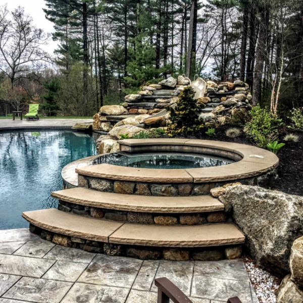 use stamped concrete for the pool deck in a timeless backyard surrounded by lush forests