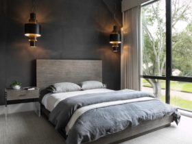 encapsulate contemporary elegance in the bedroom with black walls and grey carpet flooring