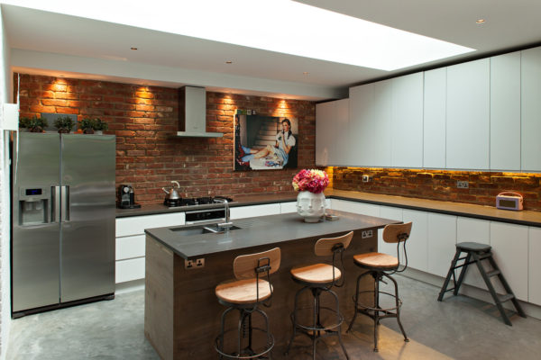install real brick walls and place brown island for a chic and eclectic white kitchen