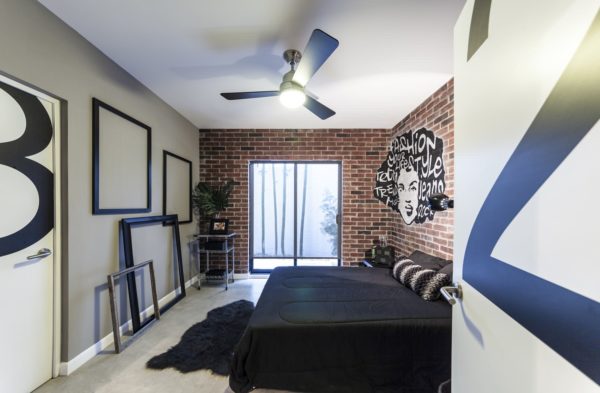 introduce black and white graffiti murals on brick wallpaper to complement the grey wall