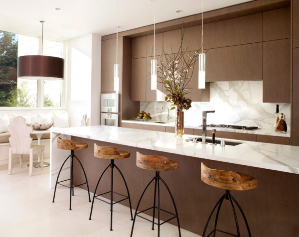 pair brown cabinetry with white marble countertops and flooring for a trendy galley kitchen
