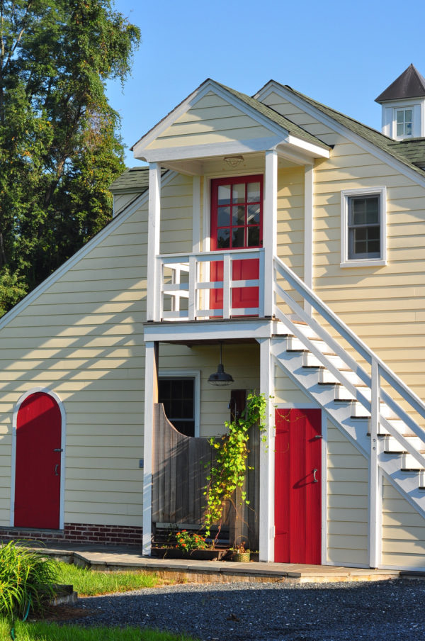 use an eye-catching roasted pepper red door to contrast beige walls for an improved curb appeal
