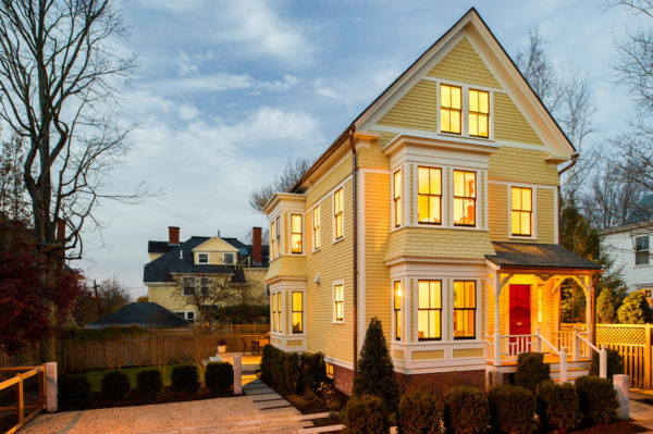 victorian style house with a charming red door and a grand three-story plan