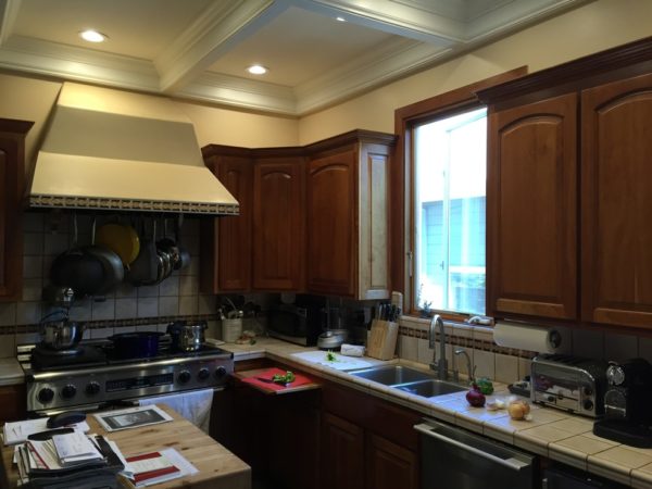 before: a small and closed off kitchen with very dim lighting and old-fashioned furniture