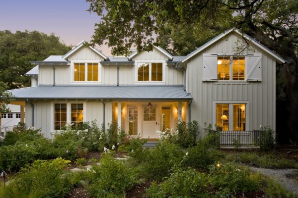 charming farmhouse home featuring white barn door window shutters in a beige exterior