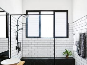 complete a contemporary bathroom with subway tile and black grout for shower walls with a wood floating vanity