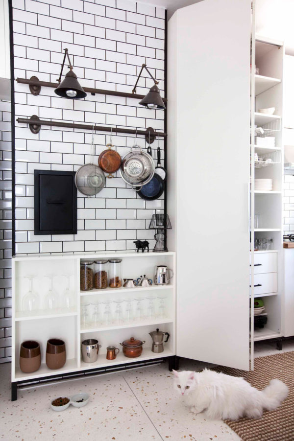 hang an antique pot rack in this contemporary kitchen with subway tile and black grout walls