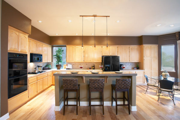 asian design featuring light brown kitchen cabinets and warm yellow lighting