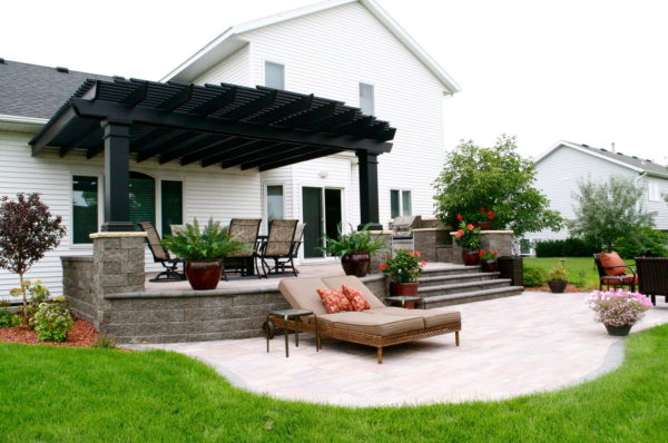 complete your raised concrete patio against the house with an outdoor kitchen and pergola