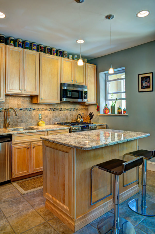 embrace the eclectic style of light brown kitchen cabinets and granite surfaces