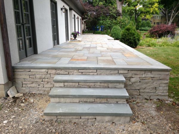 go for a raised bluestone patio against the house with matching front entry steps