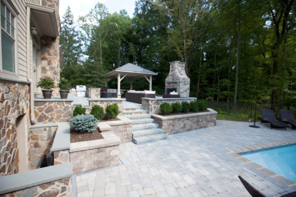 raised patio against the house for a charming backyard connecting to the pool