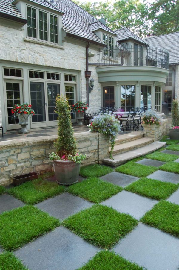 this timeless stone exterior looks classy with a raised patio against the house