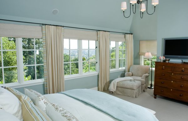 a huge bedroom featuring roman shades with beige curtains for an elegant and timeless ambiance