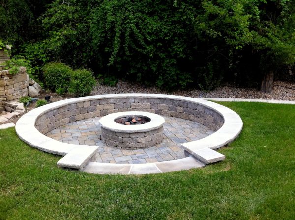 a simple recessed ground retaining wall fire pit and seat wall amid luscious greeneries