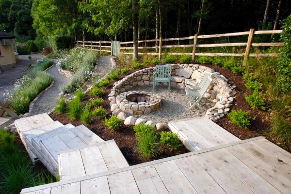 combine gravel landscaping and wildflower garden with a retaining wall fire pit for a unique and relaxing ambiance