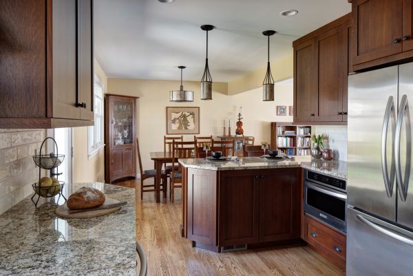 complement warm wood furnishing with granite countertops in a traditional small kitchen with a peninsula