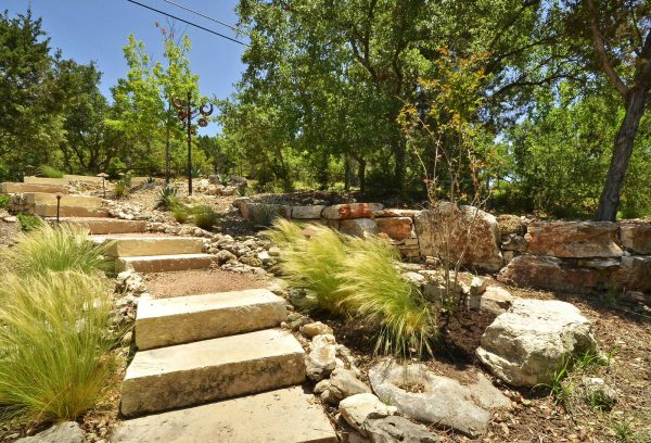 consider landscaping slopes with rocks and a brick retaining wall to accentuate the surrounding nature