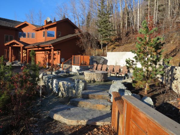 consider stone landscaping and a retaining wall fire pit in your rustic terrace