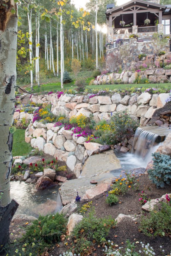 create the ultimate oasis featuring a pond, waterfall, and landscaping slopes with rocks