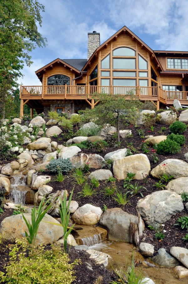 elevate your country home with rustic landscaping slopes featuring natural rocks and water fountain