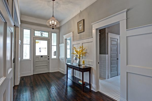 the dark wood flooring in this hall with sherwin williams mindful gray walls and eider white trim looks classic and effortlessly elegant