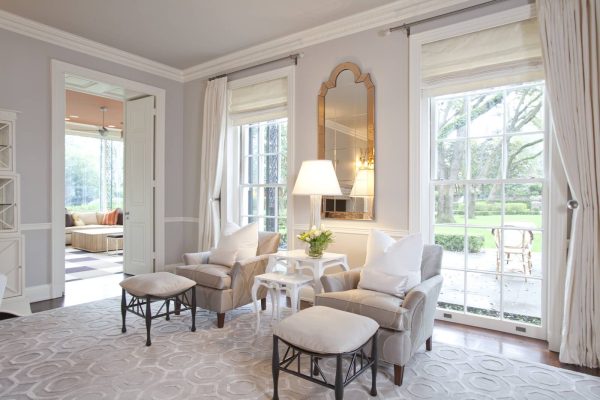 these roman shades with curtains make an enclosed living room feel lavish and bright