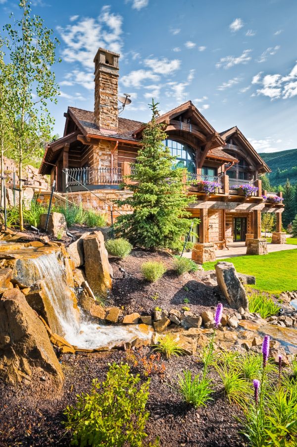 this breathtaking landscaping slope with rocks and purple flowers make for a magical scenery
