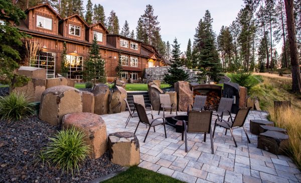 turn these landscaping slopes with rocks into a beautiful outdoor area with a fire pit
