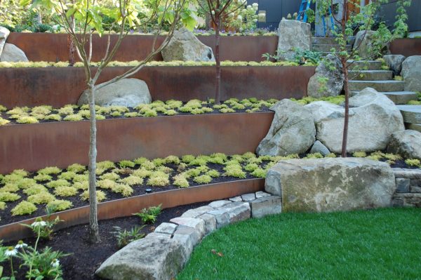 use oregon mild steel for landscaping slopes with rocks that can weather to a dark, rustic look