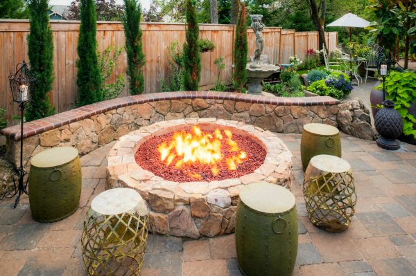use round drum seats around a retaining wall fire pit to enhance a tuscan inspired backyard
